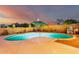 Inviting backyard pool with an umbrella, desert landscape, and block wall at 12229 N 121St Dr, El Mirage, AZ 85335