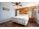 Cozy bedroom featuring wood accent wall, ceiling fan, and wood-look floors at 12229 N 121St Dr, El Mirage, AZ 85335
