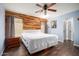 Comfortable bedroom with unique wood accent wall, fan, and soft blue walls at 12229 N 121St Dr, El Mirage, AZ 85335