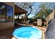 Relaxing backyard patio with a hot tub, covered seating area, and lush greenery for privacy at 13390 N 95Th Way, Scottsdale, AZ 85260