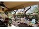Covered outdoor patio with ceiling fan, seating areas, and lush landscaping, perfect for relaxation at 13390 N 95Th Way, Scottsdale, AZ 85260