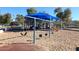 Community playground with swings, slides and climbing area covered by shade structure surrounded by sand at 13390 N 95Th Way, Scottsdale, AZ 85260