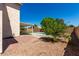 Picturesque backyard showcasing a lush tree, paved patio, gravel area, and glimpses of the inviting pool beyond at 13711 N 81St Ave, Peoria, AZ 85381