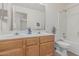 Bright bathroom features a double sink vanity, large mirror, and a shower-tub combo with white tiled surround at 13711 N 81St Ave, Peoria, AZ 85381