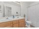 Bright bathroom features a double sink vanity, large mirror, and a shower-tub combo with a stylish shower curtain at 13711 N 81St Ave, Peoria, AZ 85381
