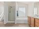 Bathroom features a tub and shower combination, wood-look floors, and neutral decor at 13711 N 81St Ave, Peoria, AZ 85381