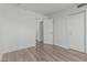 Empty bedroom features wood-look floors, white walls, closet, and an ensuite door at 13711 N 81St Ave, Peoria, AZ 85381
