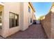 View of the side yard featuring a textured exterior wall, gravel landscaping, and a gated walkway at 13711 N 81St Ave, Peoria, AZ 85381