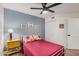 Bedroom with ceiling fan, wood flooring, closet, and a blue accent wall adorned with Gathering pictures at 1449 E Kent Ave, Chandler, AZ 85225