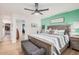 Comfortable main bedroom features a ceiling fan, wood flooring, and tufted bench at the foot of the bed at 1449 E Kent Ave, Chandler, AZ 85225