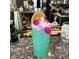 A vibrant blue cocktail garnished with an orange slice and flower, set on a speckled granite bar top at 1619 E Del Rio Dr, Tempe, AZ 85282