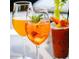 A colorful cocktail garnished with a flower, presented among other beverages on an outdoor restaurant table at 1619 E Del Rio Dr, Tempe, AZ 85282