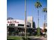 Exterior view of Thirsty Lion Gastropub featuring outdoor seating, palm trees, and passersby on a sunny day at 1619 E Del Rio Dr, Tempe, AZ 85282