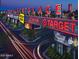 A vibrant Tempe Marketplace entrance illuminated with bright retail signage and lush landscaping at twilight at 1619 E Del Rio Dr, Tempe, AZ 85282
