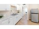 This bright kitchen features stainless steel appliances, white cabinets and tile floors at 1624 W Thomas Rd, Phoenix, AZ 85015