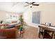 Cozy living room with vaulted ceilings, ceiling fan, tile flooring, modern furniture, and large window at 1624 W Thomas Rd, Phoenix, AZ 85015
