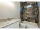 Modern bathroom with a granite vanity, tub, and shower featuring decorative tile and ample lighting at 16405 N Cobblestone Ln, Fountain Hills, AZ 85268