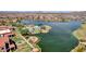 Lakeside view of a pool, seating, and patio area surrounded by mature palms and lush landscaping at 17002 S 178Th Ave, Goodyear, AZ 85338