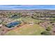 Aerial view showcasing tennis courts, clubhouse, and green spaces in a vibrant community at 17002 S 178Th Ave, Goodyear, AZ 85338