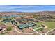 Aerial view showcasing the community clubhouse, pool, tennis courts, and lake at 17002 S 178Th Ave, Goodyear, AZ 85338