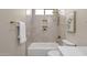 Bathroom featuring a white tiled shower-tub with a small corner shelf, gold fixtures, and a towel rack at 17002 S 178Th Ave, Goodyear, AZ 85338