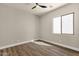 Bright bedroom featuring a ceiling fan and wood-look floors, with a large window providing ample natural light at 17002 S 178Th Ave, Goodyear, AZ 85338