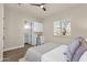 Comfortable bedroom with a mini bar, ceiling fan, plantation shutters, and adjacent bathroom at 17002 S 178Th Ave, Goodyear, AZ 85338
