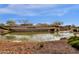 Beautiful community entrance with a pond, lush landscaping, and the 'CANTAMIA' sign at 17002 S 178Th Ave, Goodyear, AZ 85338