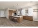 Bright, modern kitchen featuring two-tone cabinets, island with seating, and stainless appliances at 17002 S 178Th Ave, Goodyear, AZ 85338