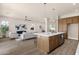 Open-concept living area with view of kitchen and seating at the island at 17002 S 178Th Ave, Goodyear, AZ 85338