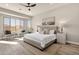 Bright main bedroom featuring wood-look floors, a ceiling fan, and a comfortable sitting area by a window at 17002 S 178Th Ave, Goodyear, AZ 85338