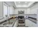 Well-equipped kitchen featuring stainless steel appliances, bright white cabinets, and ample countertop space at 17241 N 16Th Dr # 1, Phoenix, AZ 85023