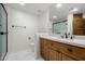 Modern bathroom with a granite countertop vanity and walk-in shower featuring black trim at 18116 N 14Th St, Phoenix, AZ 85022