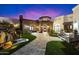Gorgeous custom home showcasing a stone facade, a beautiful water feature, and lush landscaping at sunset at 18116 N 14Th St, Phoenix, AZ 85022