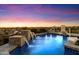 Sparkling blue pool featuring stone waterfalls and a basketball hoop, set against a beautiful sunset backdrop at 18116 N 14Th St, Phoenix, AZ 85022