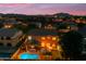 Aerial view of the house with a glowing pool, patio, and mountain views in the background at 18460 E Peachtree Blvd, Queen Creek, AZ 85142