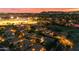 Scenic aerial neighborhood view showcasing rooftops, tree lined streets, and illuminated sports field at 18460 E Peachtree Blvd, Queen Creek, AZ 85142