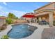 Inviting backyard features a sparkling pool with water features, patio, and barbecue at 18460 E Peachtree Blvd, Queen Creek, AZ 85142