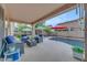 Inviting covered patio area with comfortable seating, swimming pool, and manicured landscaping at 18460 E Peachtree Blvd, Queen Creek, AZ 85142