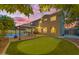 Private backyard oasis with a pool, putting green, covered patio, and beautifully landscaped surroundings at 18460 E Peachtree Blvd, Queen Creek, AZ 85142