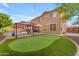 Resort backyard featuring putting green, built-in barbecue, and seating area at 18460 E Peachtree Blvd, Queen Creek, AZ 85142