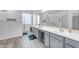 Bright bathroom featuring a double vanity, framed mirror, textured walls, and wood-look tile flooring at 18460 E Peachtree Blvd, Queen Creek, AZ 85142