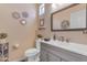 Cozy bathroom featuring a gray vanity, modern sink, and decorative wall mirrors at 18460 E Peachtree Blvd, Queen Creek, AZ 85142