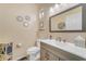 Charming powder room with decorative mirrors, vanity and fixtures, and a neutral color palette at 18460 E Peachtree Blvd, Queen Creek, AZ 85142