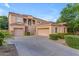 Well-maintained two-story home featuring a spacious three-car garage and landscaped front yard at 18460 E Peachtree Blvd, Queen Creek, AZ 85142