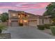 Stunning two-story home with a three-car garage, elegant facade, and beautifully landscaped front yard at 18460 E Peachtree Blvd, Queen Creek, AZ 85142