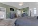 Comfortable main bedroom with gray furniture, a TV, and access to a bright sunroom at 18460 E Peachtree Blvd, Queen Creek, AZ 85142
