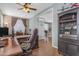 Spacious office with wood floors, large desk, ceiling fan, and glass paneled door to living room at 18460 E Peachtree Blvd, Queen Creek, AZ 85142