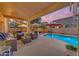 Inviting covered patio features comfortable seating, string lights, overlooking pool at 18460 E Peachtree Blvd, Queen Creek, AZ 85142