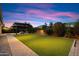 Spacious backyard with lush artificial grass and a cozy pergola-covered fire pit at 1874 E Crescent Way, Chandler, AZ 85249